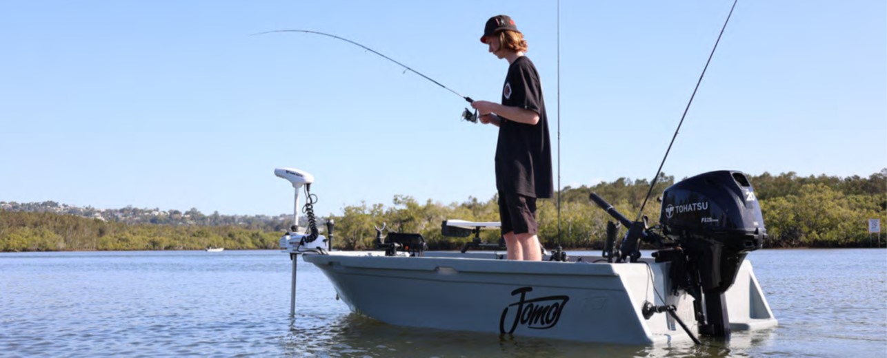 man-standing-in-small-power-fishing-boat-trolling-motor-outboard